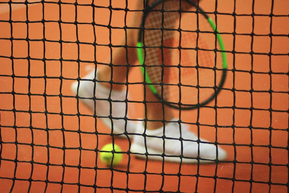 Female playing tennis on court